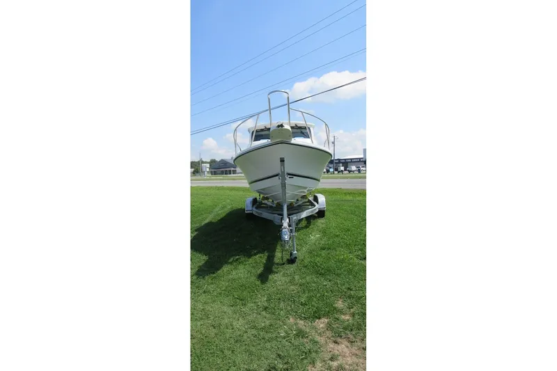Slide: The Image of Front view of a 2027 Parker 217 Explorer boat on a trailer, parked on grass. - 2