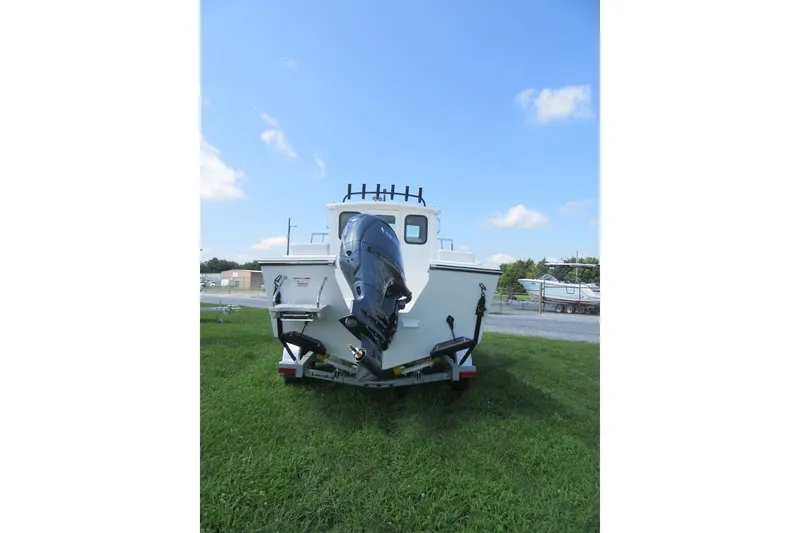 Slide: The Image of 2027 Parker 217 Explorer boat on grass, rear view with outboard motor. - 4