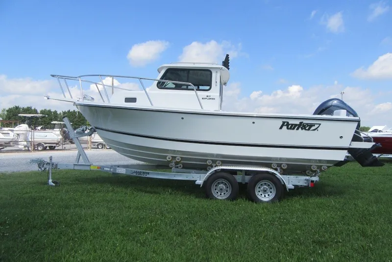 Slide: The Image of 2027 Parker 217 Explorer boat on trailer, parked on grass under blue sky. - 3