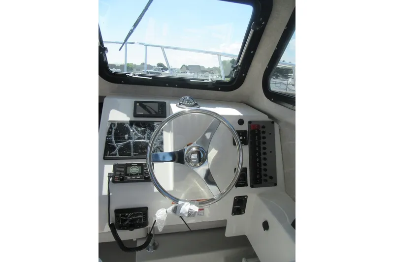 Slide: The Image of Helm of 2027 Parker 217 Explorer boat with steering wheel and control panel. - 17
