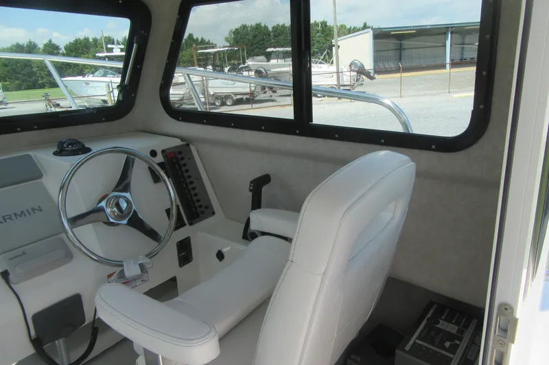 Slide: The Image of Interior of a 2027 Parker 217 Explorer boat with steering wheel and controls. - 13