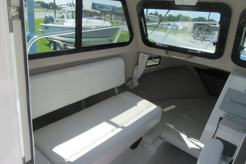 Slide: The Image of Interior of a 2027 Parker 217 Explorer boat with white seating and large windows. - 12
