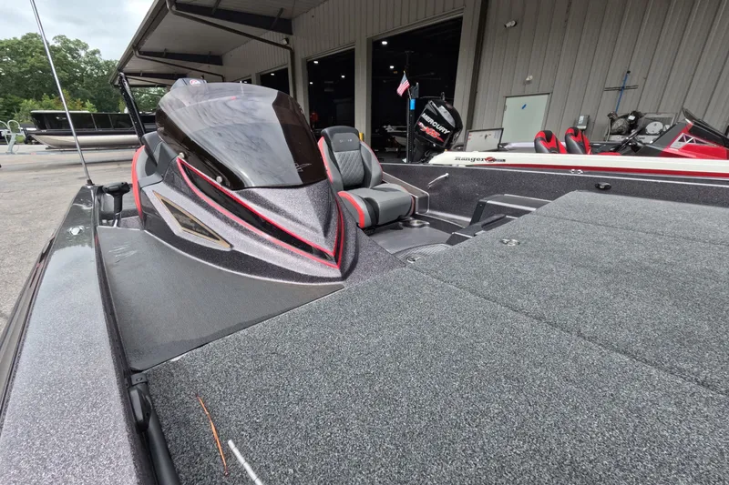 Slide: The Image of 2021 Caymas boat with sleek design and modern seating, parked near a garage. - 21