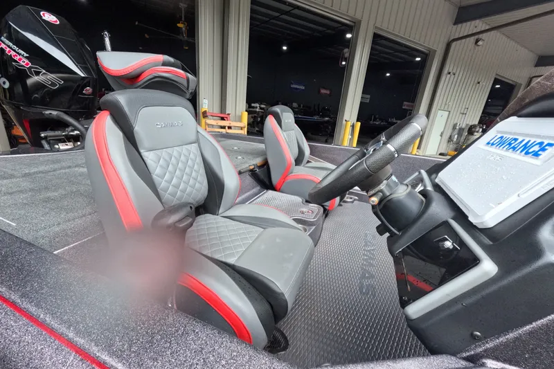 Slide: The Image of 2021 Caymas boat interior with red and gray seats, steering wheel, and Lowrance equipment. - 5