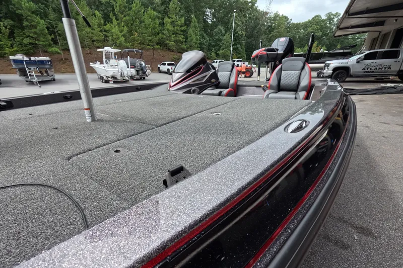 Slide: The Image of 2021 Caymas boat with sleek design, spacious deck, and comfortable seating, parked outdoors. - 25