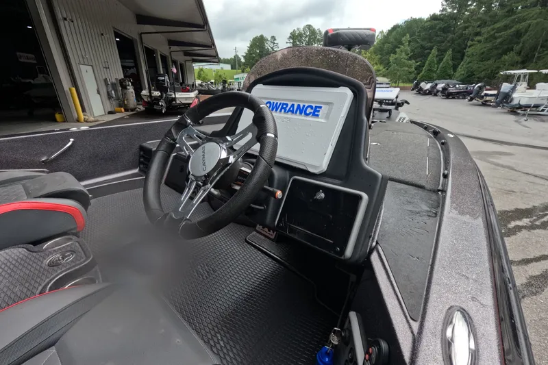 Slide: The Image of 2021 Caymas boat cockpit with steering wheel and Lowrance display at a marina. - 6