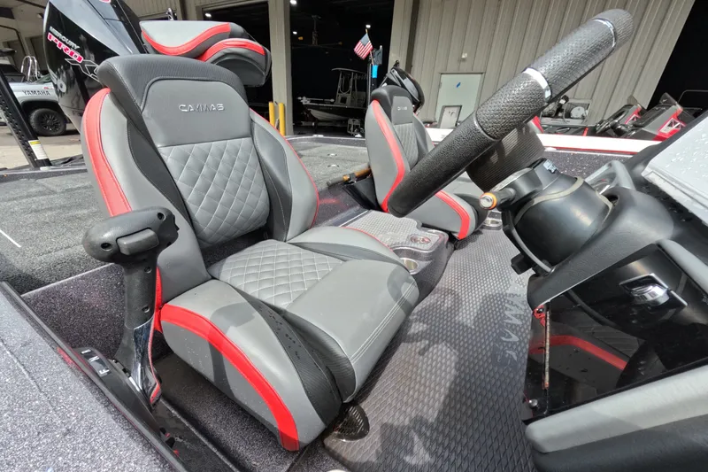 Slide: The Image of 2021 Caymas boat interior with gray and red seats, steering wheel, and dashboard. - 32