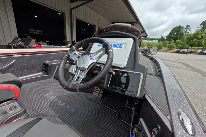 Slide: The Image of 2021 Caymas boat cockpit with steering wheel and navigation display, parked near a building. - 31