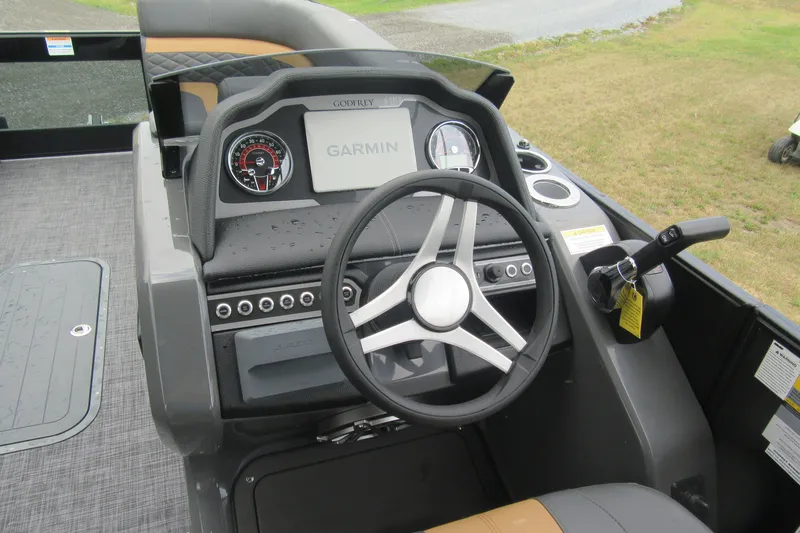 Slide: The Image of 2027 Godfrey Monaco 235 ULC boat dashboard with Garmin navigation system and steering wheel. - 9