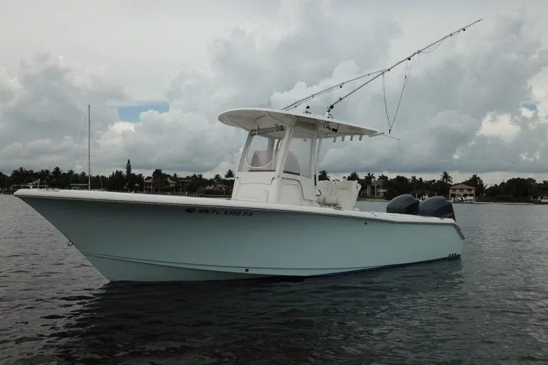 Slide: The Image of 2014 Sea Hunt Gamefish 25 boat on calm water under cloudy sky. - 1