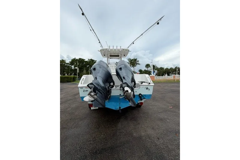 Slide: The Image of 2014 Sea Hunt Gamefish 25 boat with dual outboard motors, parked on a wet surface. - 8