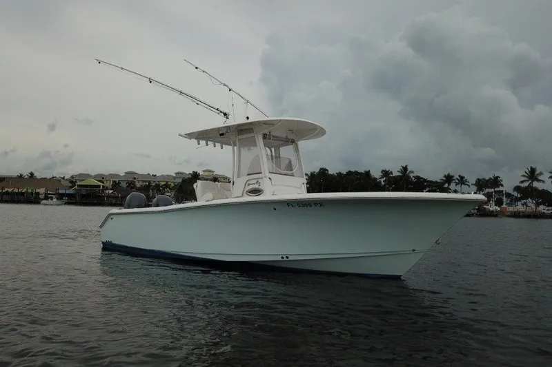 The Image of 2014 Sea Hunt Gamefish 25 boat on calm water under cloudy sky. - 0