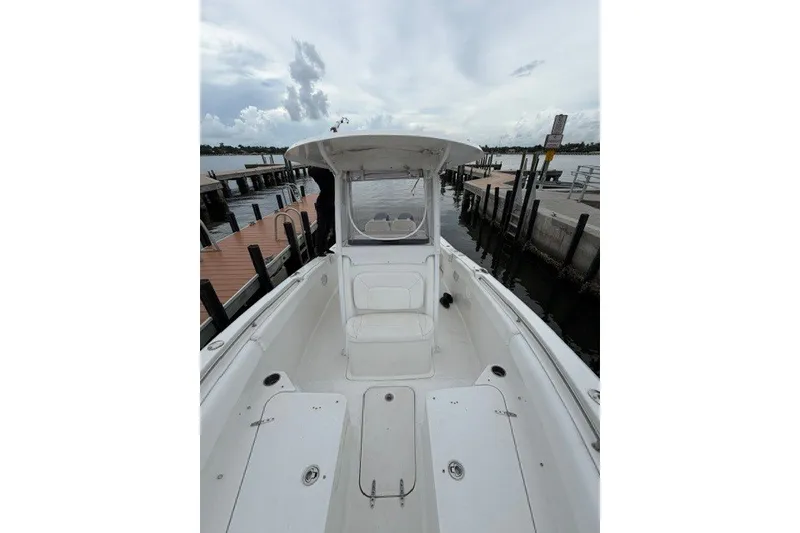 Slide: The Image of 2014 Sea Hunt Gamefish 25 boat docked at marina under cloudy sky. - 12