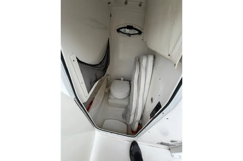 Slide: The Image of 2014 Sea Hunt Gamefish 25 boat interior with compact toilet and storage area. - 13