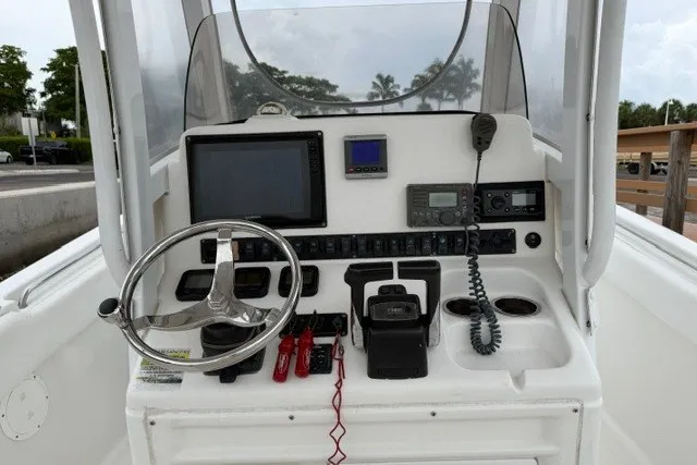 Slide: The Image of 2014 Sea Hunt Gamefish 25 helm with steering wheel, electronics, and controls. - 9
