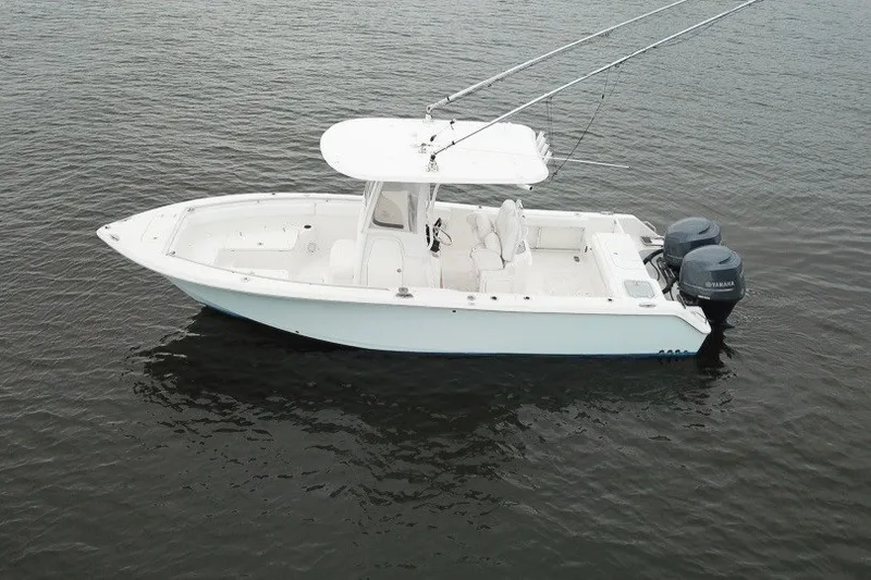 Slide: The Image of 2014 Sea Hunt Gamefish 25 boat on calm water, featuring dual outboard motors. - 3