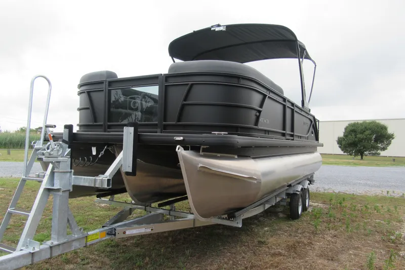 Slide: The Image of 2027 Godfrey Sweetwater 2286 SFLC pontoon boat on trailer, parked outdoors. - 2