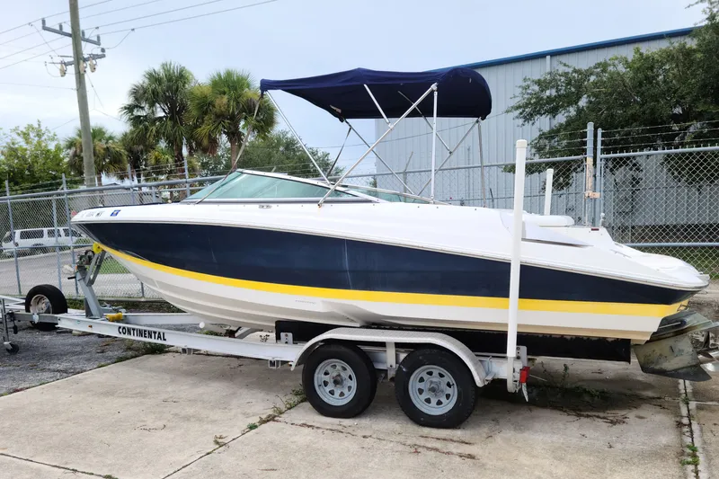 The Image of 2005 Regal 2200 Bowrider boat on trailer, parked outdoors near a fence. - 0