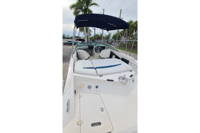 Slide: The Image of 2005 Regal 2200 Bowrider boat with canopy, white seating, and sleek design. - 16