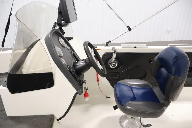 Slide: The Image of 2012 Ranger 1860 Angler boat cockpit with steering wheel and blue seat. - 8