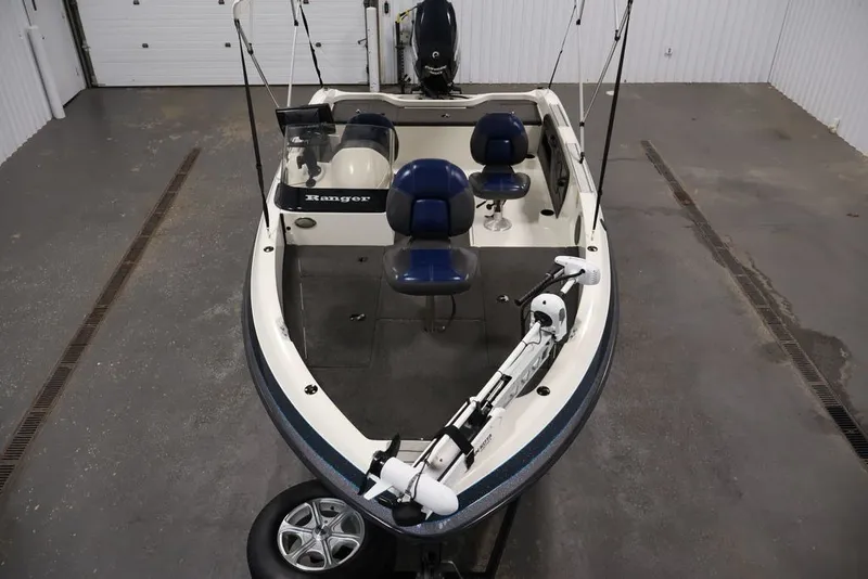 Slide: The Image of 2012 Ranger 1860 Angler boat with blue seats in a garage setting. - 10
