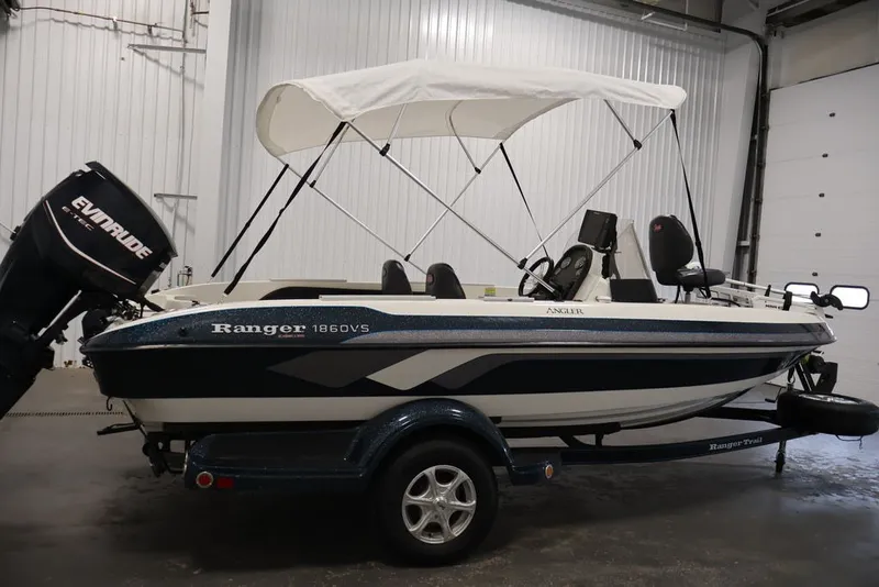 Slide: The Image of 2012 Ranger 1860 Angler boat with Evinrude motor and canopy in a garage. - 6