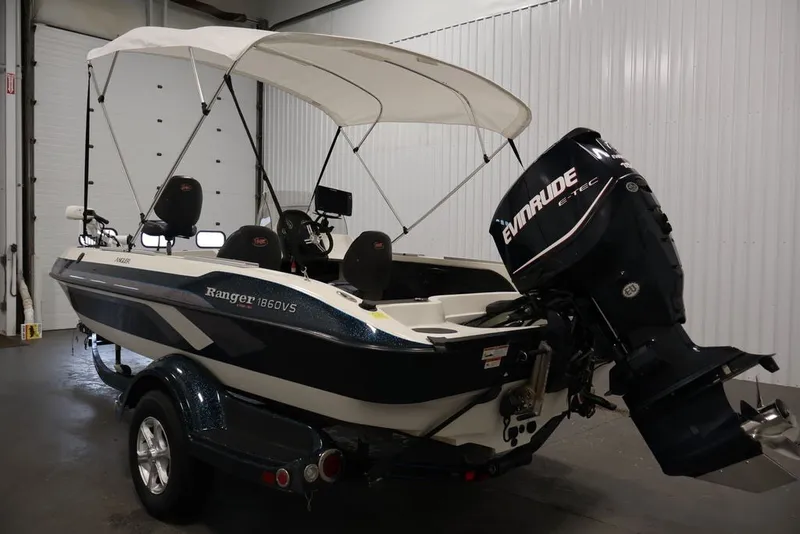 Slide: The Image of 2012 Ranger 1860 Angler boat with Evinrude motor and canopy in a garage. - 5
