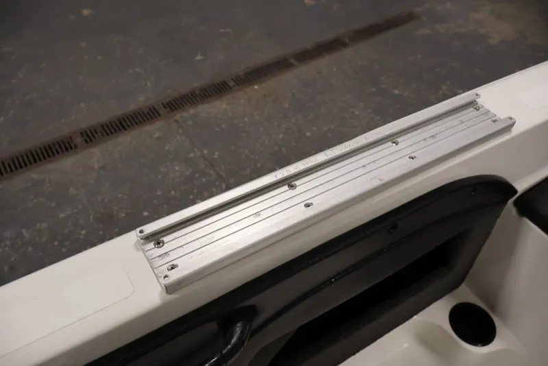 Slide: The Image of 2012 Ranger 1860 Angler boat detail showing metal rail and storage compartment. - 20