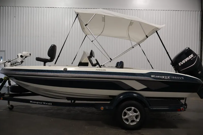 Slide: The Image of 2012 Ranger 1860 Angler boat with canopy and Evinrude motor in a showroom. - 13