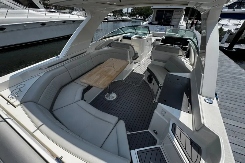 Slide: The Image of 2021 Sea Ray SLX 350 Outboard boat interior with spacious seating and wooden table. - 8