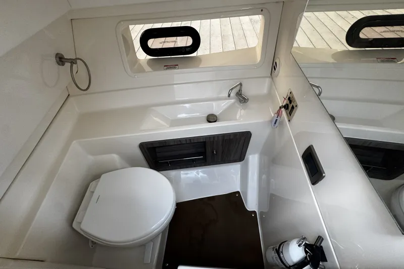 Slide: The Image of 2021 Sea Ray SLX 350 Outboard bathroom with sink, toilet, and window. - 21