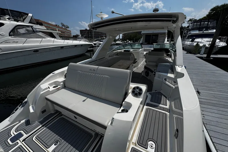 Slide: The Image of 2021 Sea Ray SLX 350 Outboard boat docked, showcasing luxurious seating and sleek design. - 7