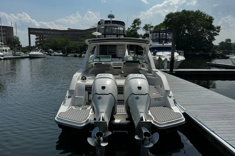 Slide: The Image of 2021 Sea Ray SLX 350 Outboard docked at marina, rear view with twin engines. - 2