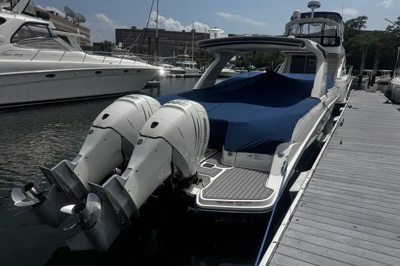 Slide: The Image of 2021 Sea Ray SLX 350 Outboard boat docked with twin engines, covered in blue tarp. - 4