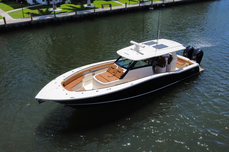 Slide: The Image of 2021 Scout 425 LXF luxury boat cruising on a calm waterway. - 14