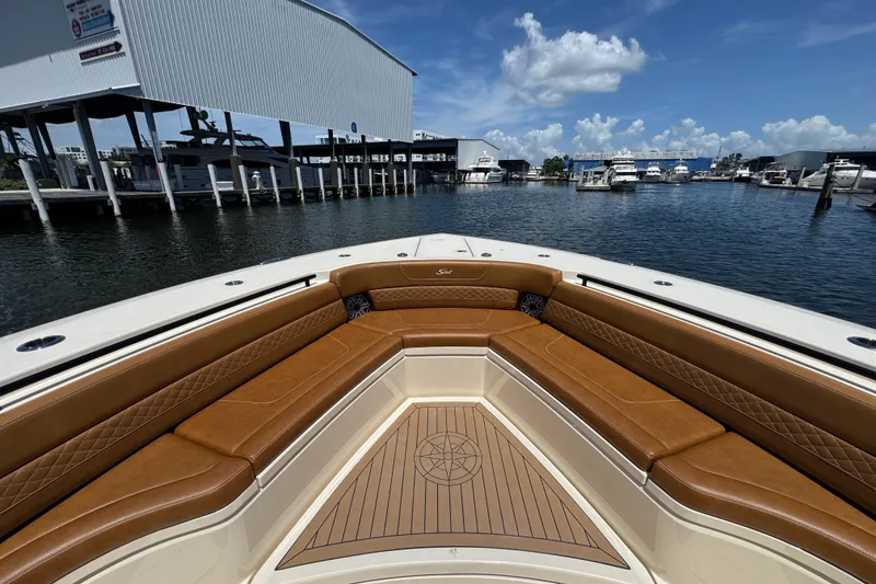 Slide: The Image of 2021 Scout 425 LXF boat interior with luxurious seating at a marina. - 22