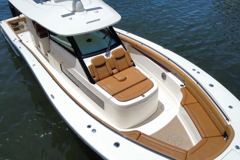 Slide: The Image of 2021 Scout 425 LXF luxury boat with tan seating on calm water. - 21