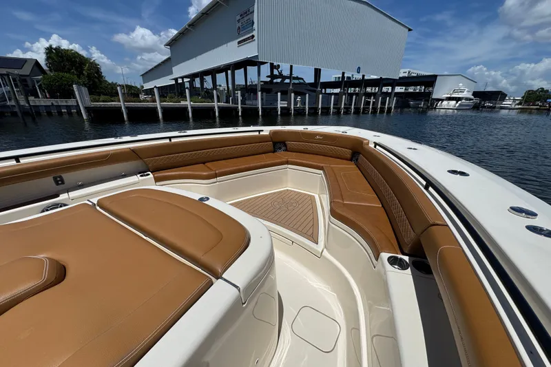 Slide: The Image of 2021 Scout 425 LXF boat with luxurious tan seating, docked near a marina. - 23