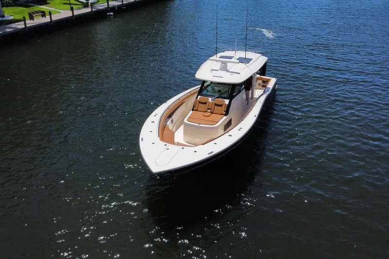 Slide: The Image of 2021 Scout 425 LXF boat cruising on a sunny waterway. - 19