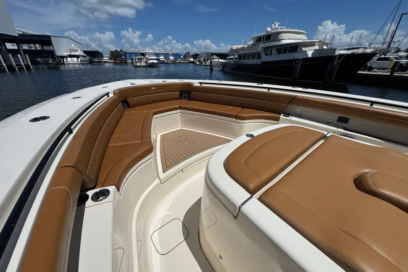Slide: The Image of Luxurious 2021 Scout 425 LXF boat interior with tan seating, docked at marina. - 24