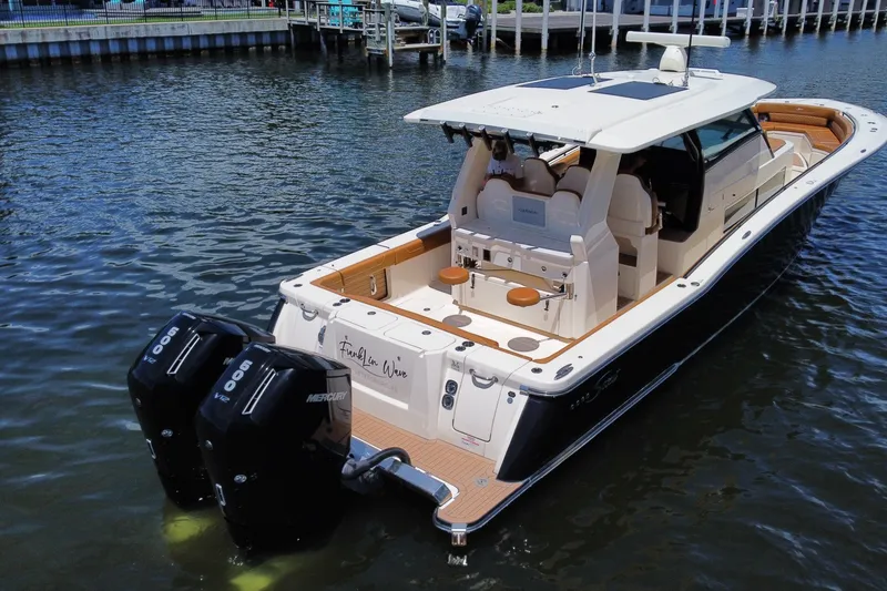 Slide: The Image of 2021 Scout 425 LXF luxury boat with dual Mercury engines docked in marina. - 18