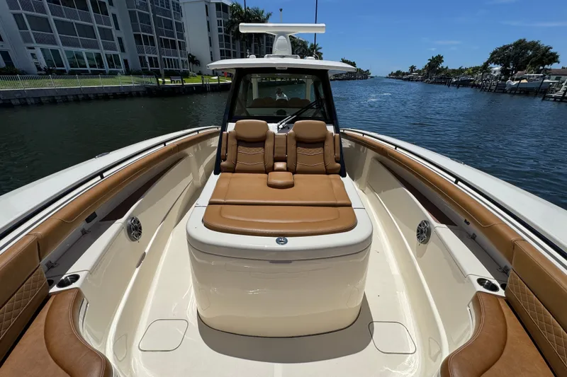 Slide: The Image of 2021 Scout 425 LXF boat with luxurious tan seating on a sunny waterway. - 26