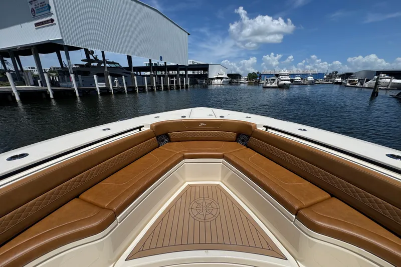 Slide: The Image of Luxurious 2021 Scout 425 LXF boat interior with brown leather seating at a marina. - 25