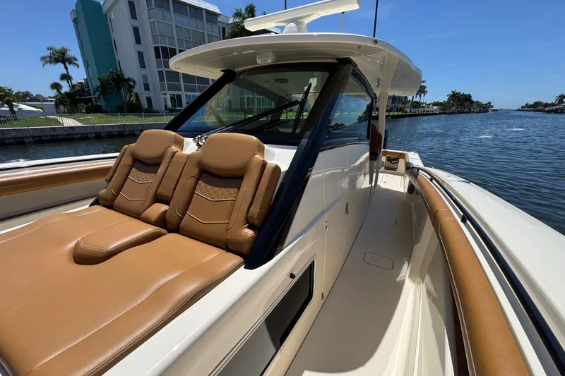 Slide: The Image of 2021 Scout 425 LXF boat with luxurious seating, docked by waterfront buildings. - 28