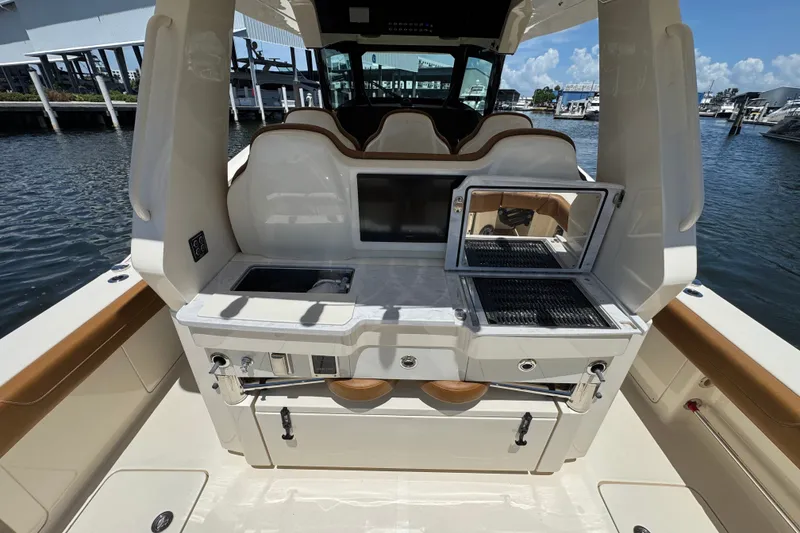 Slide: The Image of 2021 Scout 425 LXF boat interior with grill and sink, docked at marina. - 34