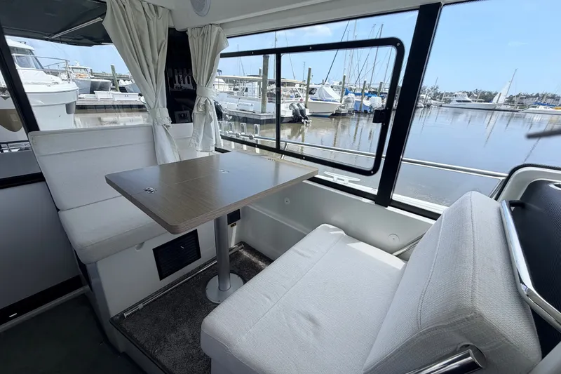 Slide: The Image of Interior of 2026 Jeanneau NC 895 Sport Series 2, featuring a cozy dining area with marina view. - 26