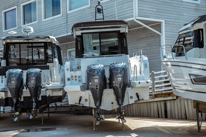 Slide: The Image of 2025 Jeanneau NC 895 Sport Series 2 with dual outboard engines, docked at marina. - 3