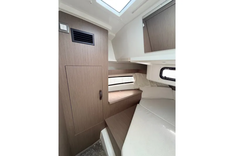 Slide: The Image of Interior cabin of 2026 Jeanneau NC 895 Sport Series 2, featuring wood paneling and a cozy bed. - 42
