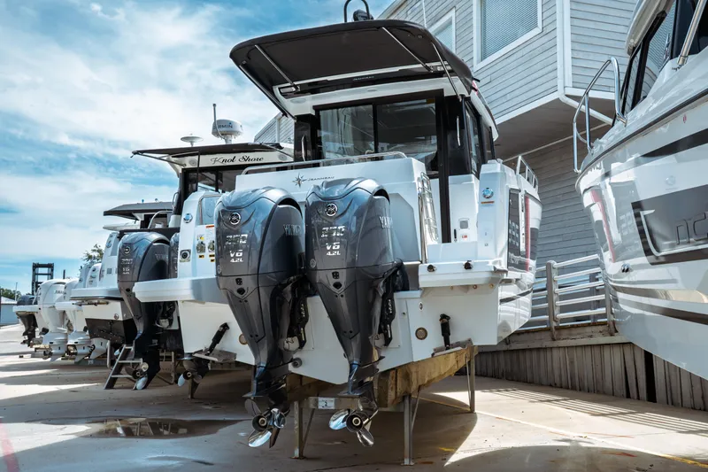 Slide: The Image of 2025 Jeanneau NC 895 Sport Series 2 boats with dual outboard engines at a marina. - 1