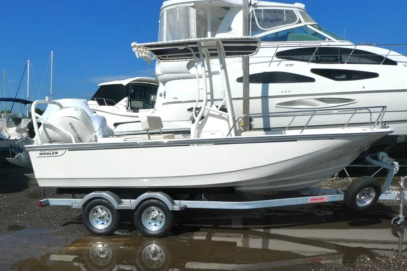 Slide: The Image of 2027 Boston Whaler 190 Montauk boat on trailer, parked at marina. - 2